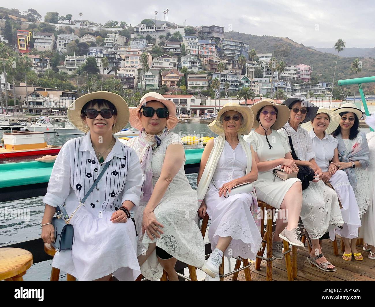 Un groupe de femmes visitant l'île de Santa Catalina au large des côtes de la Californie du Sud pose pour un portrait de groupe sur la jetée d'Avalon, Californie, États-Unis Banque D'Images