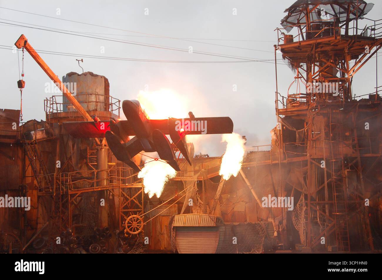 Un hydravion s'écrase en flammes pendant le spectacle de cascades Waterworld à Universal Studios Hollywood, entouré d'explosions et d'un éclairage spectaculaire Banque D'Images