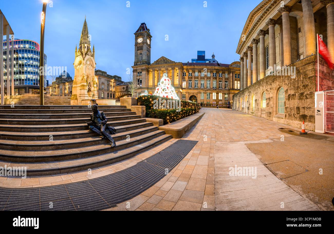 Une scène nocturne à Birmingham avec la statue de Sir Thomas Adwood sur des marches courbes, un sapin de Noël brillant et des façades historiques, capturant la ville Banque D'Images