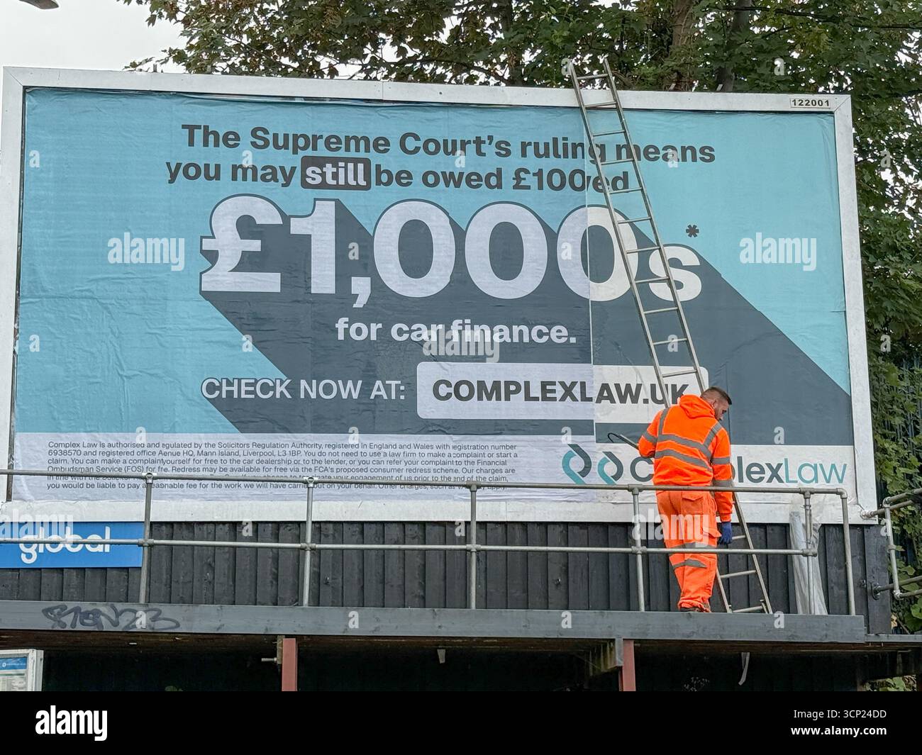 Un homme sur une échelle met en place une affiche géante sur panneau d'affichage, affichant une publicité qui dit : « la décision de la Cour suprême signifie que vous pouvez toujours être redevable de £100. » ROYAUME-UNI Banque D'Images