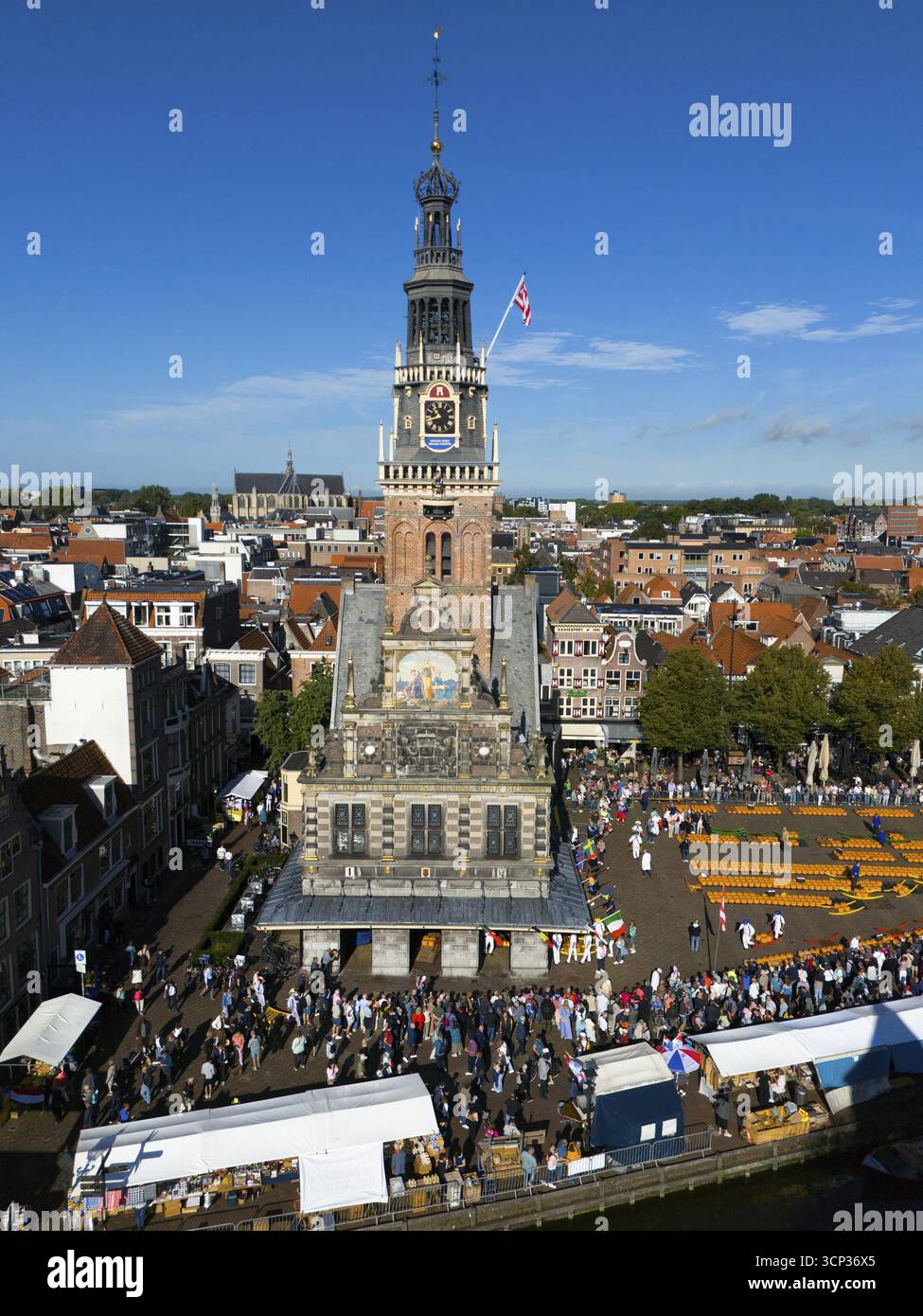 Imposante tour de l'horloge avec une activité de marché animée et des étals de marché au premier plan, sous le ciel bleu, vue aérienne, fromage, marché au fromage, ancienne ville Banque D'Images