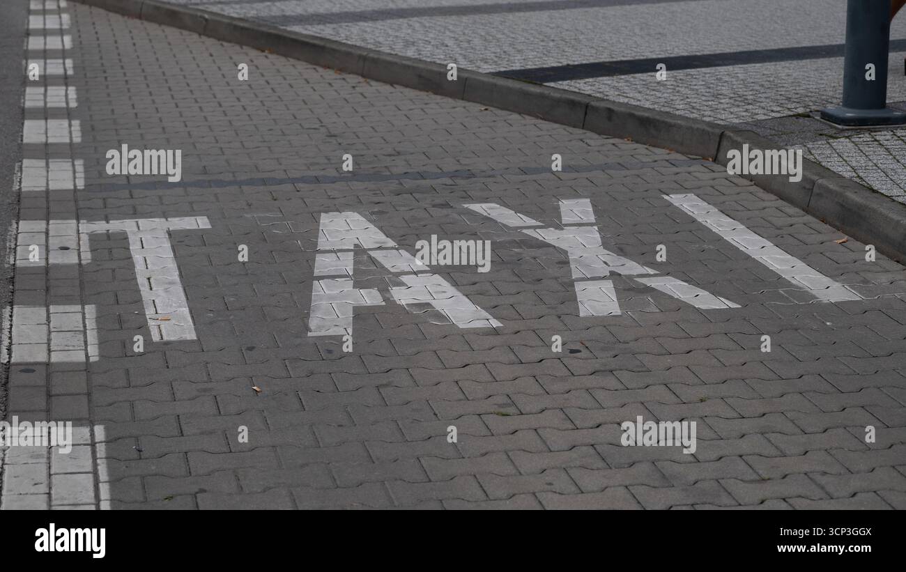Parking de taxi marqué sur une rue pavée avec des lettres peintes en blanc sur le sol. Cette image peut être utilisée pour illustrer le transport urbain, taxi Ser Banque D'Images
