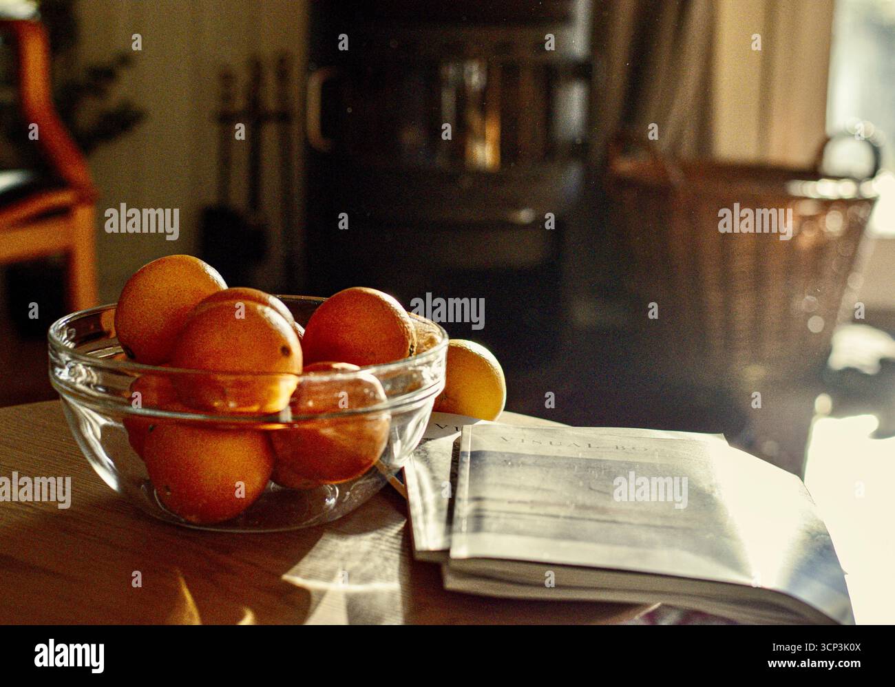 bol glas d'oranges et de magazines devant la cheminée Banque D'Images