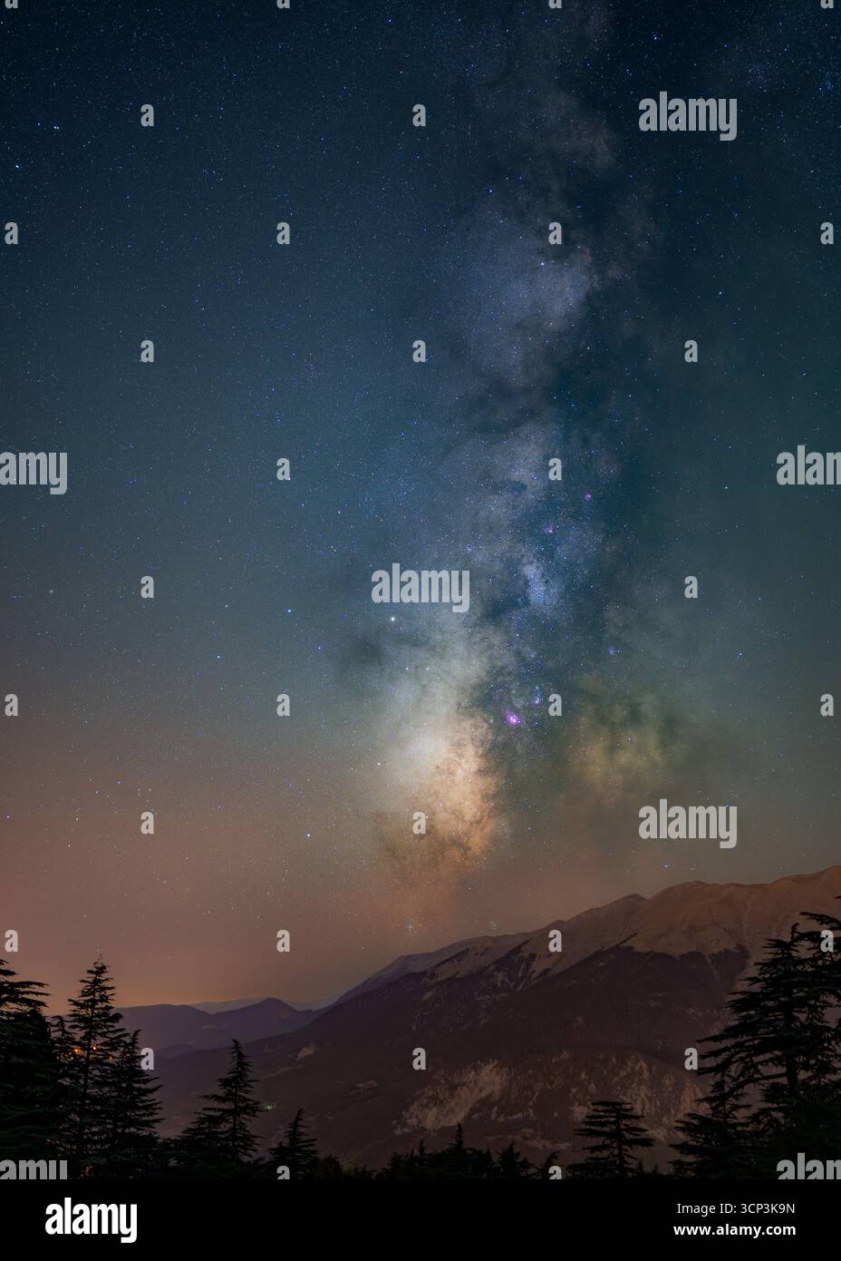 Voie lactée voûtant au-dessus de la crête de montagne et de la forêt la nuit Banque D'Images Voie lactée voûtant au-dessus de la crête de montagne et de la forêt la nuit Banque D'Images