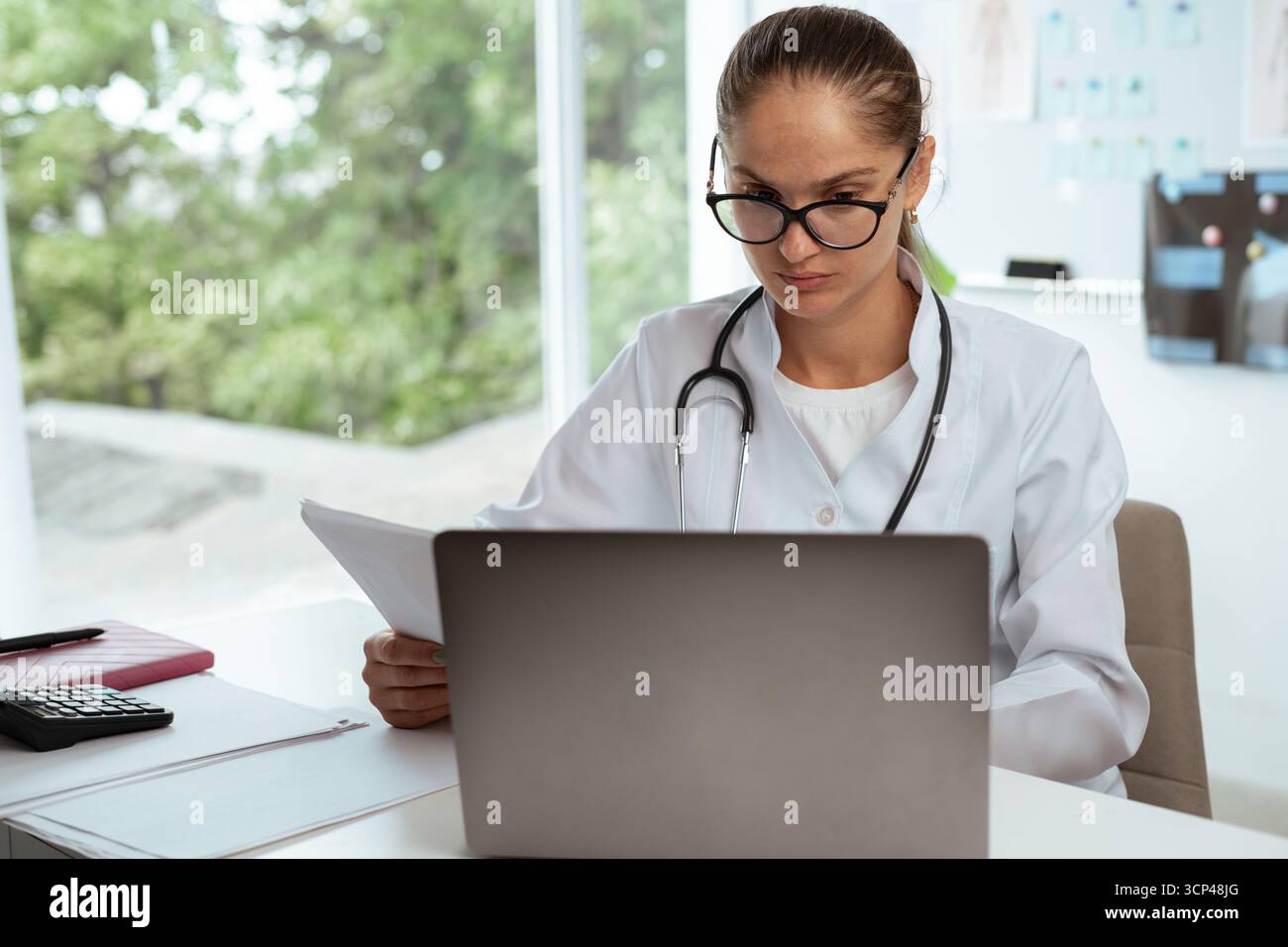 Femme médecin lisant des documents papier examinant le dossier médical en cabinet hospitalier. concept de médecine Banque D'Images