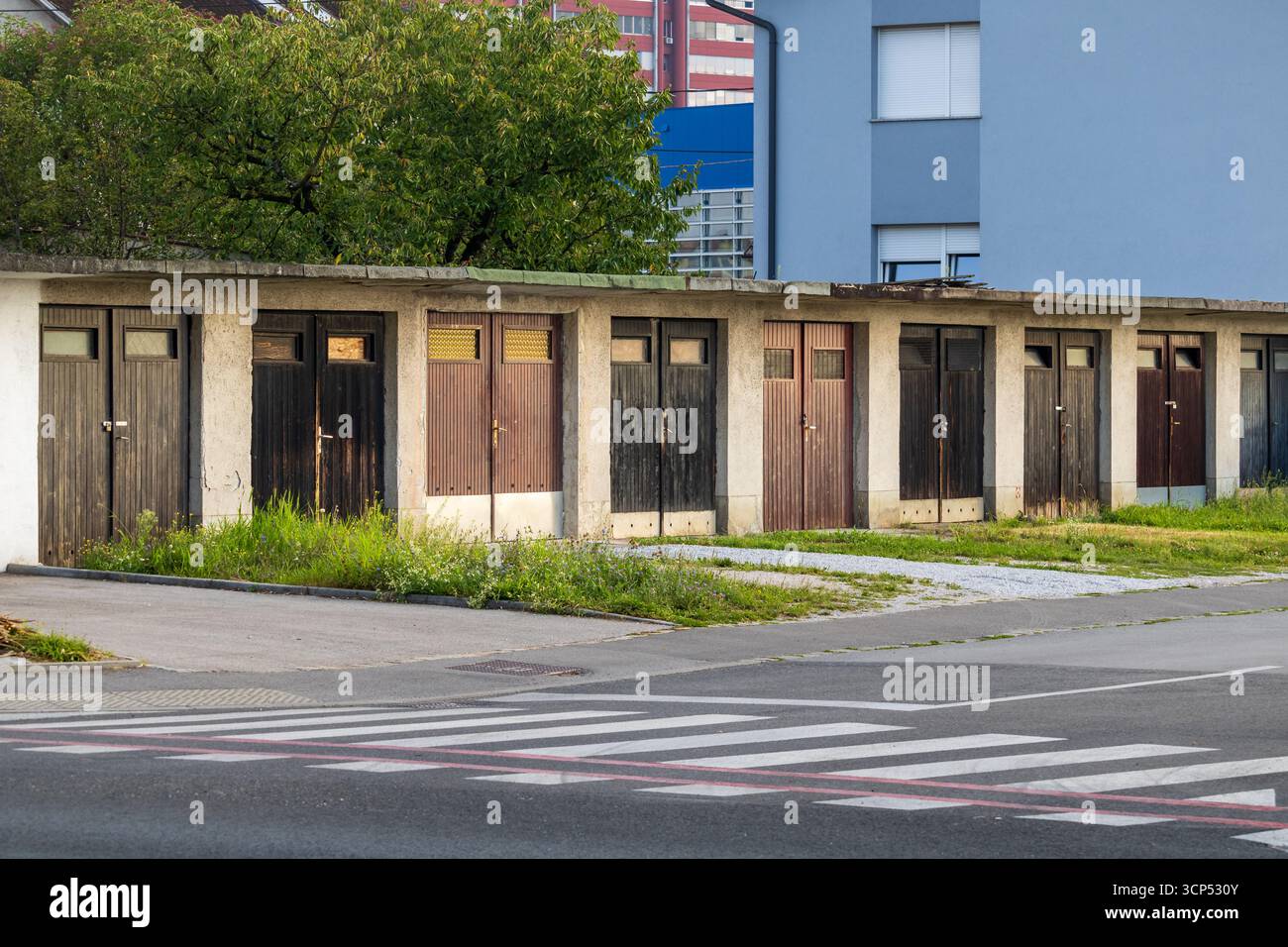 rangée de portes de garage colorées le long du trottoir urbain, façade de garage urbain Banque D'Images