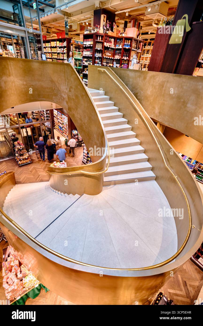 Vienne, Autriche – intérieur d'un grand magasin moderne avec un escalier en colimaçon doré comme pièce maîtresse architecturale. Banque D'Images