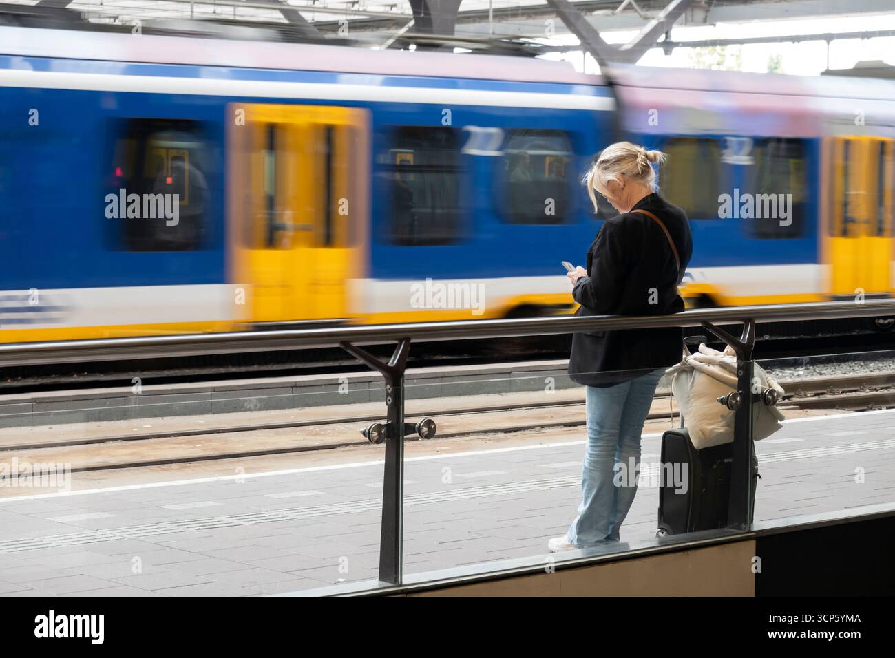 Femme attendant le train sur le quai de la gare centrale de Rotterdam, Rotterdam, pays-Bas, Europe Banque D'Images