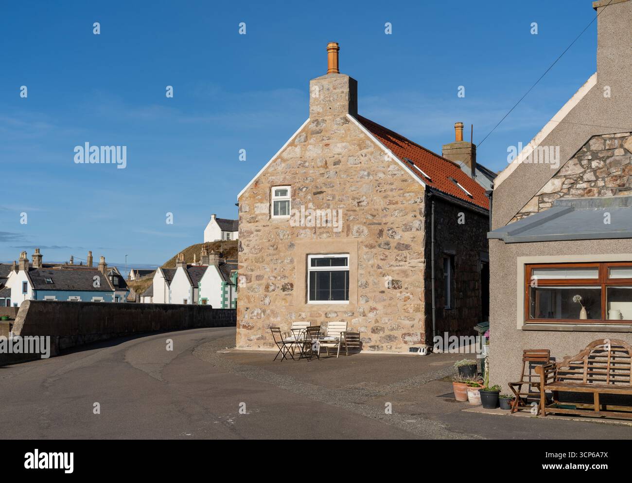 Il s'agit de sièges en dehors des maisons de vacances dans le village de pêcheurs de Findochty, Moray, Écosse par un après-midi ensoleillé Banque D'Images