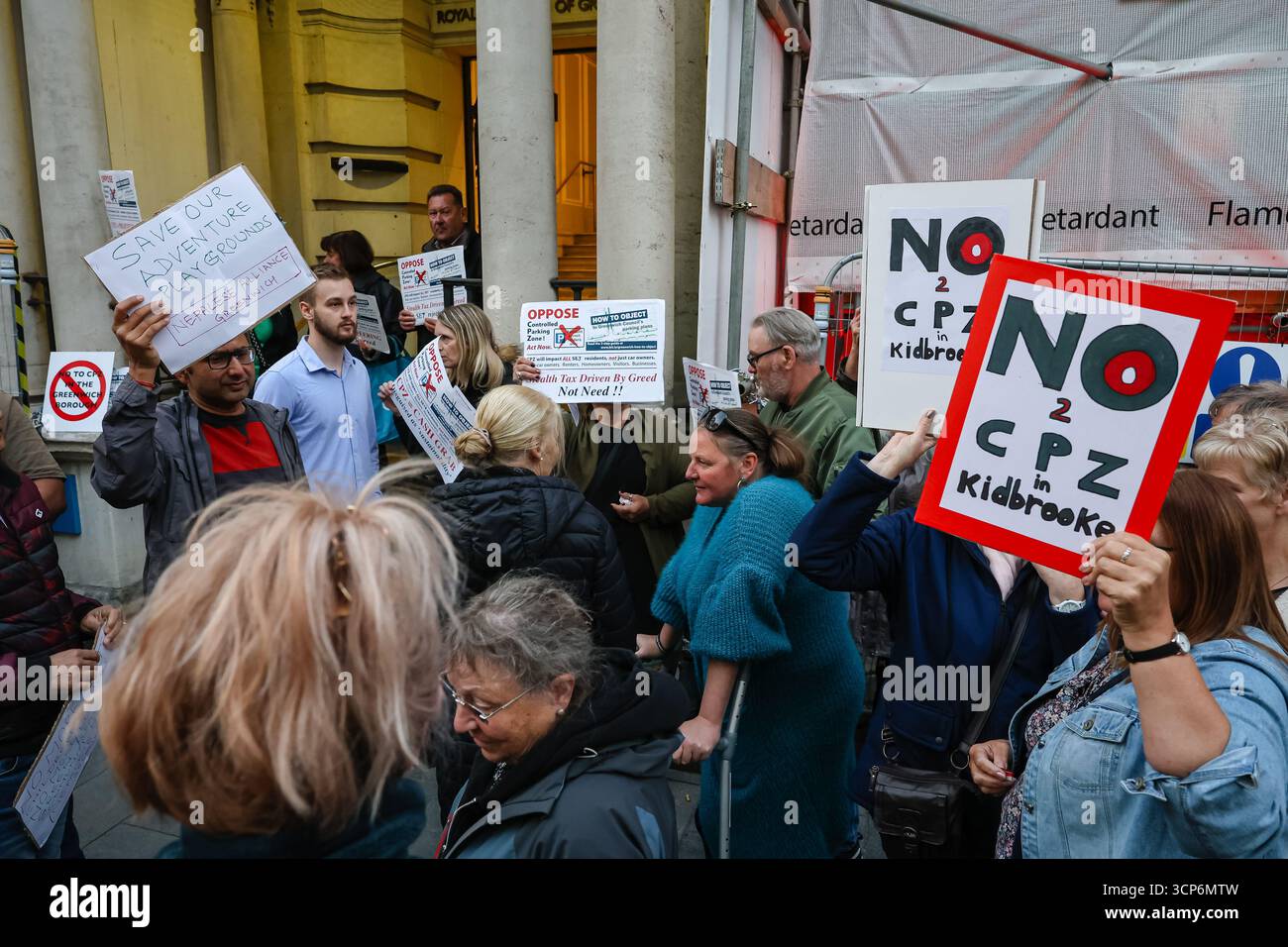 LONDRES, Royaume-Uni - 24 septembre 2025 : confusion devant le conseil municipal de Greenwich alors que trois manifestations distinctes ont eu lieu en même temps - des militants appelant au désinvestissement des fonds de pension d'Israël, des résidents s'opposant à des coupes dans les terrains de jeux d'aventure et des résidents s'opposant à un système de zones de stationnement contrôlées. Les manifestants se sont mélangés entre eux, certains tenant les mauvaises pancartes et enseignes, car les différentes causes se chevauchaient devant la mairie. Banque D'Images