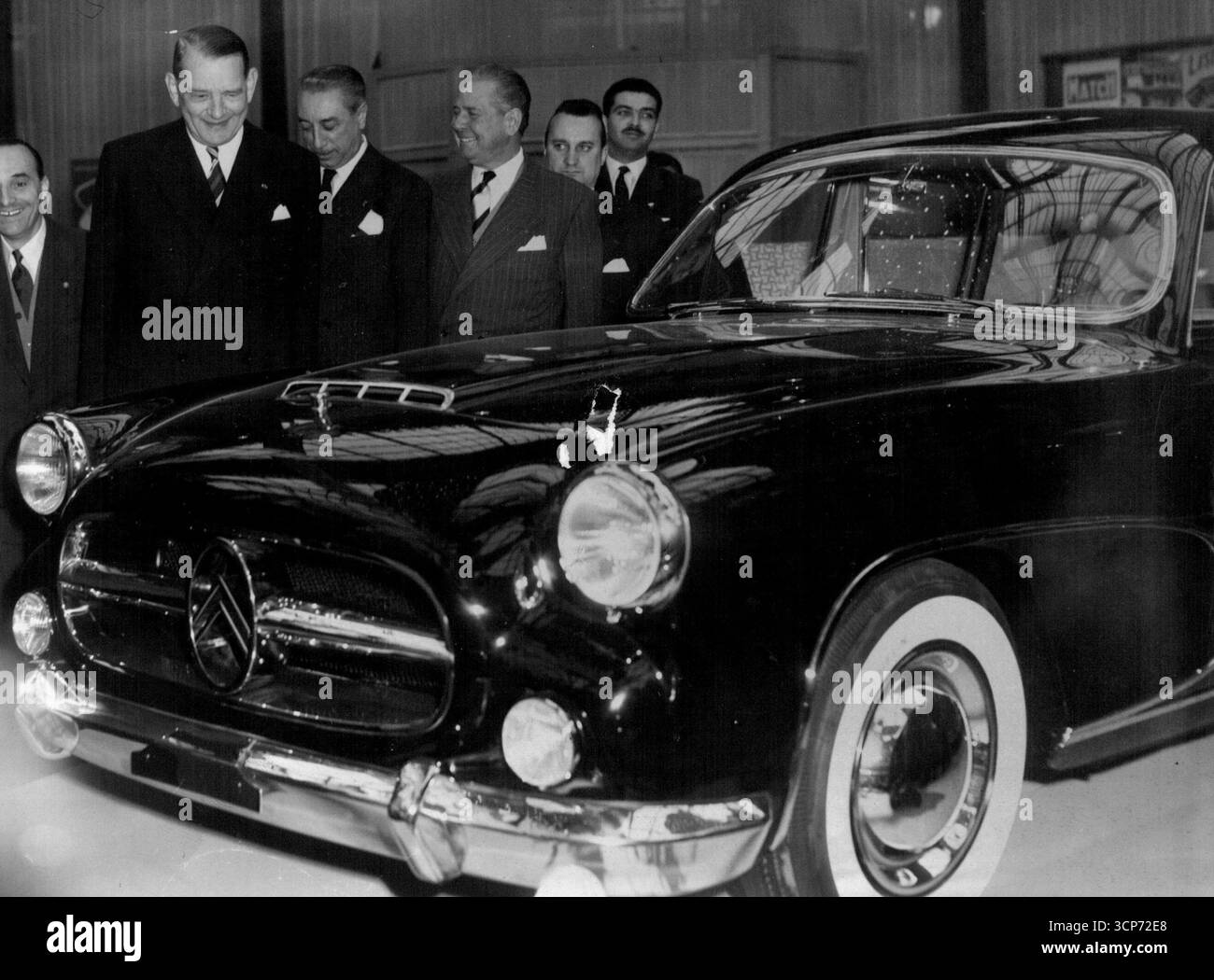Voiture neuve pour Coty -- le président de la République française René Coty semble très heureux par la berline noire spécialement construite Citroën qu'il regarde au salon annuel de l'automobile à Paris. La grande limousine portant le double chevron familier de la marque CITROEN a été commandée pour la marque CITROEN a été commandée pour le président et sera utilisée pour des voyages officiels dès que le salon sera terminé. 7 octobre 1955. (Photo de United Press photo). Banque D'Images