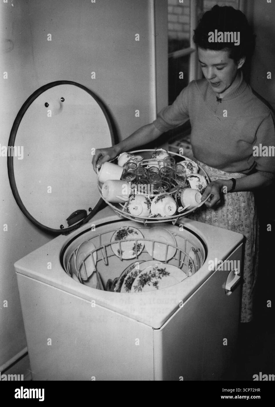 New machine fait la vaisselle dans la maison - après le réfrigérateur et la machine à laver vient la dernière idée pour la maison britannique moderne-le lave-vaisselle électrique. Miss Joyce Toll est vue en démonstration de la nouvelle machine, le « Dishmaster » - introduit de Nouvelle-Zélande - au 151, Great Portland Street, Londres, aujourd'hui (mardi). Au tour d'un bouton, il va laver, rincer et sécher la vaisselle. Le lavage prend une à deux minutes, le rinçage une minute. Coût de fonctionnement de la machine est d'environ un centime par jour. 07 octobre 1952. (Photo de Reuterphoto). Banque D'Images