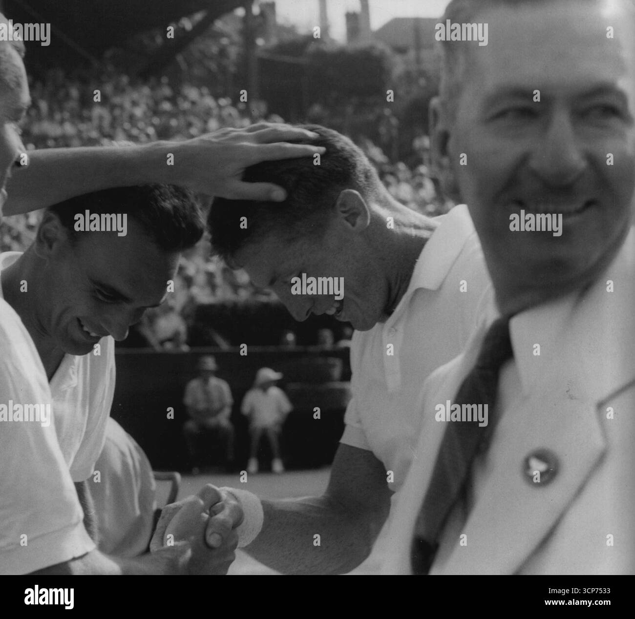 Coupe Davis 1954US Capt. Bill Talbert tape Tony Trabert sur la tête après que Seixas ait remporté la Coupe de retour pour les US Vic Seixas Looks arbitre Cliff Sproule est sur la droite. 6 janvier 1955. Banque D'Images