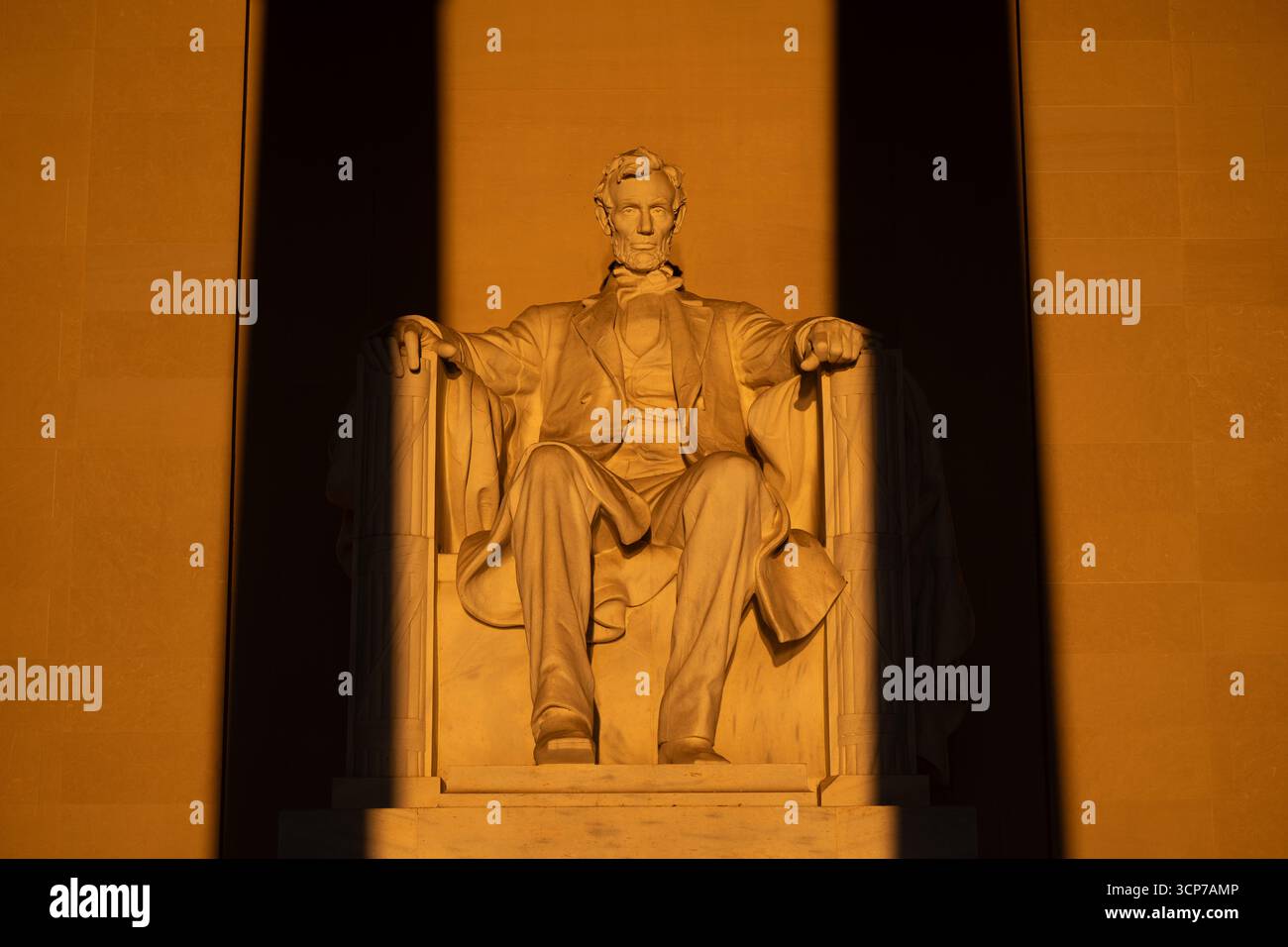 Lincoln Memorial Sunrise Washington DC // WASHINGTON DC — le lever du soleil illumine la statue d'Abraham Lincoln à l'intérieur du Lincoln Memorial le 23 mars 2025. L'éclairage naturel projette une lueur dorée sur la sculpture en marbre, avec deux ombres verticales provenant des colonnes avant du mémorial. Ce phénomène se produit autour de l'équinoxe vernal lorsque le soleil se lève directement à l'est, permettant à la lumière du soleil de pénétrer dans la chambre principale. La statue est en marbre et a été sculptée par Daniel Chester French. Le Lincoln Memorial est un monument national honorant le 16e président des États-Unis. Banque D'Images