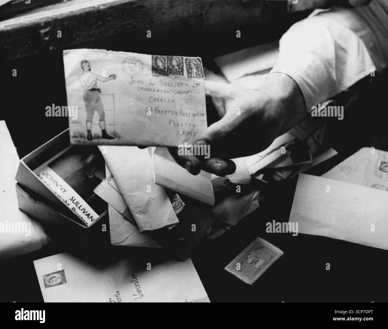 Parmi son courrier de fan John reçoit une enveloppe avec un dessin grossier de son célèbre homonyme, John L. Sullivan. 10 janvier 1955. (Photo de Haries H. Hewitt) Banque D'Images
