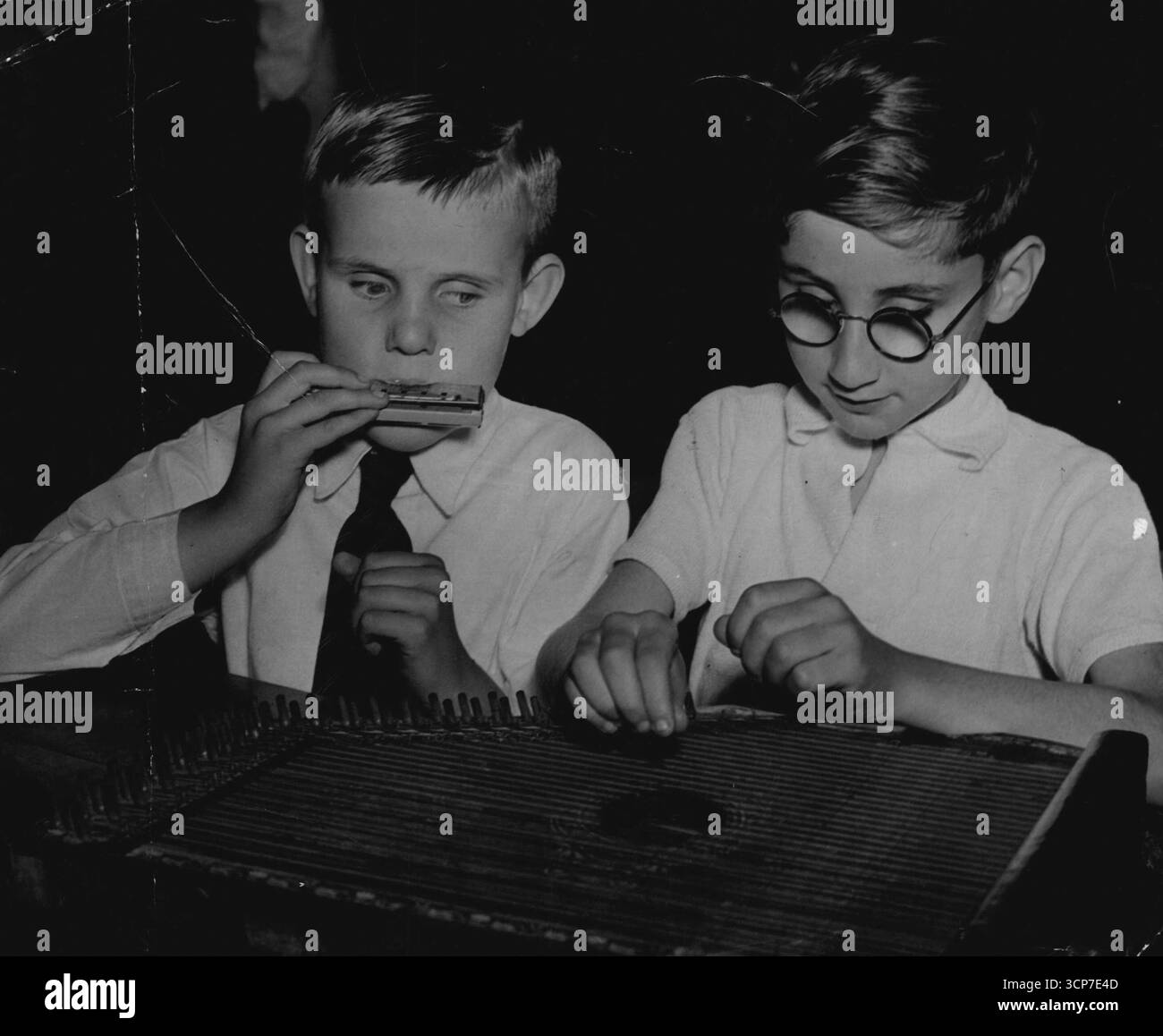 Musiciens. Gregory Dacey, 9 ans, joue de l'orgue à bouche tandis que Leo Braun, 12 ans, tape un instrument de harpe. Les enfants apprennent les cours normaux à l'oral et en braille, ainsi que l'artisanat, le tricot, le tissage, la confection de tapis. Les élèves avancés sont envoyés dans les écoles secondaires. 19 octobre 1949. Banque D'Images