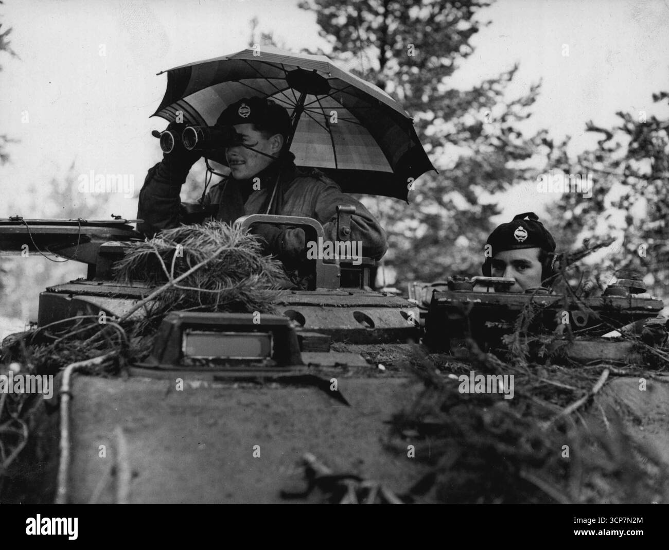Entièrement blindé, Lieut. Jack Parker, de Guernesey (Angl.), un chef de troupe dans la 5e Batt. Royal Tank Regiment, se protège contre la pluie alors qu'il prend son char Centurion en action lors de manœuvres sur les chaînes près de ***** Dans la zone britannique de l'Allemagne. 26 avril 1952. Banque D'Images
