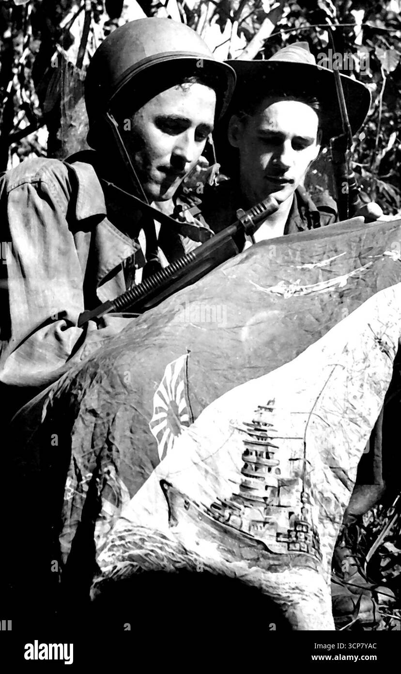 Capture alliée de Mubo. Le sergent Robert Clark de Los Angeles et le caporal Horrie Panye de Drummoyne, N.S.W., avec un pennant de Jap capturé pendant les combats à Nassau Bay. Le fant a été illustré avec un croquis représentant la marine et l'aviation de Jap en action. 5 août 1943. (Photo du ministère de l'information du Commonwealth d'Australie). Banque D'Images