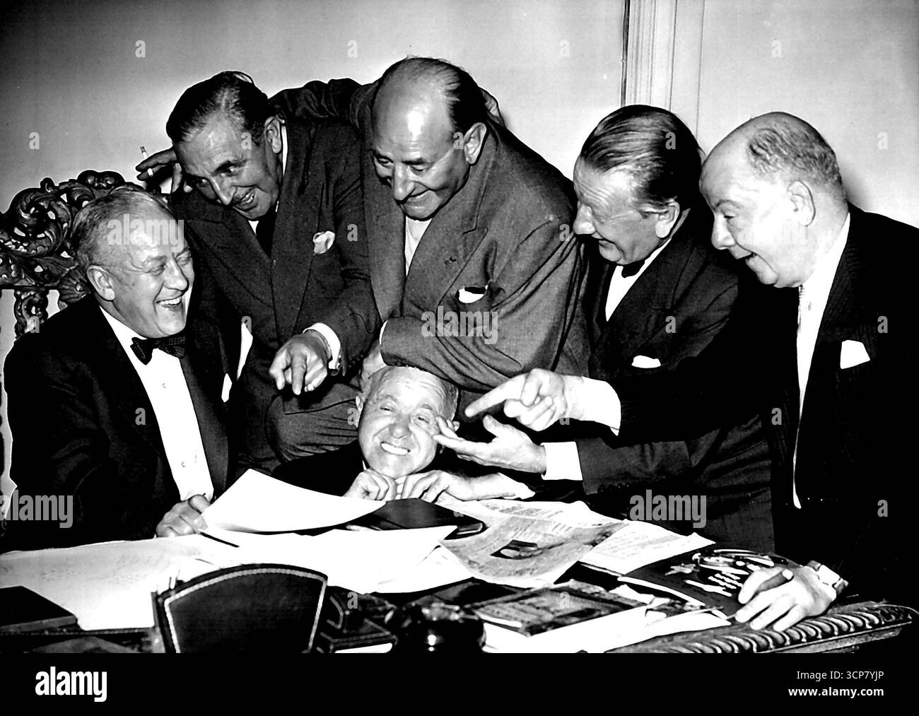 Crazy Gang laissez tomber dans le bureau de Jack Hilton Jack Hylton à son bureau aujourd'hui, entouré par le Crazy Gang qui n'est jamais hors service. La célèbre collection de comédiens de slapstick Crazy Gang était aujourd'hui le bureau londonien de Jack Hylton pour parler des arrangements de la prochaine revue Coronation, 'Ring Out the Bells' qui ouvre à Oxford à la fin de la nuit, et arrive à Londres début novembre. Comme d'habitude lors d'une de ces visites, il y avait du pandémonium dans le bureau de Hylton, que Jack, perforce, a pris dans le bon plaisir. 01 octobre 1952. (Photo Fox photos). Banque D'Images