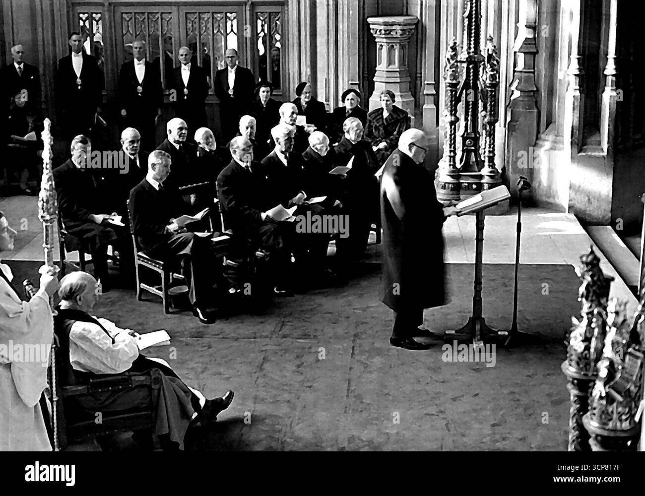 Churchill Unveills Memorial Window à Westminster Hall - la scène à Westminster Hall pendant le discours de M. Churchill après le dévouement. Sur la gauche se trouve le Dr Fisher, archevêque de Canterbury. Assis derrière M. Churchill sont (première rangée, de gauche à droite): Le duc de Wellington, Lord Simons, M. W.S. Morrison (Président), M. C. Attlee. Le marquis de Salisbury. (Rangée arrière, de gauche à droite) :- RT. L'honorable David Ecoles, RT. L'honorable Clement Davies, Lord Milner, Sir Ninian Comper, le vicomte Samuel, le Marquiis de Cholmondeley. Les dames (à droite) sont, de gauche à droite: Mme Morrison, Mme Churchill, Mme Davies et Mme Banque D'Images