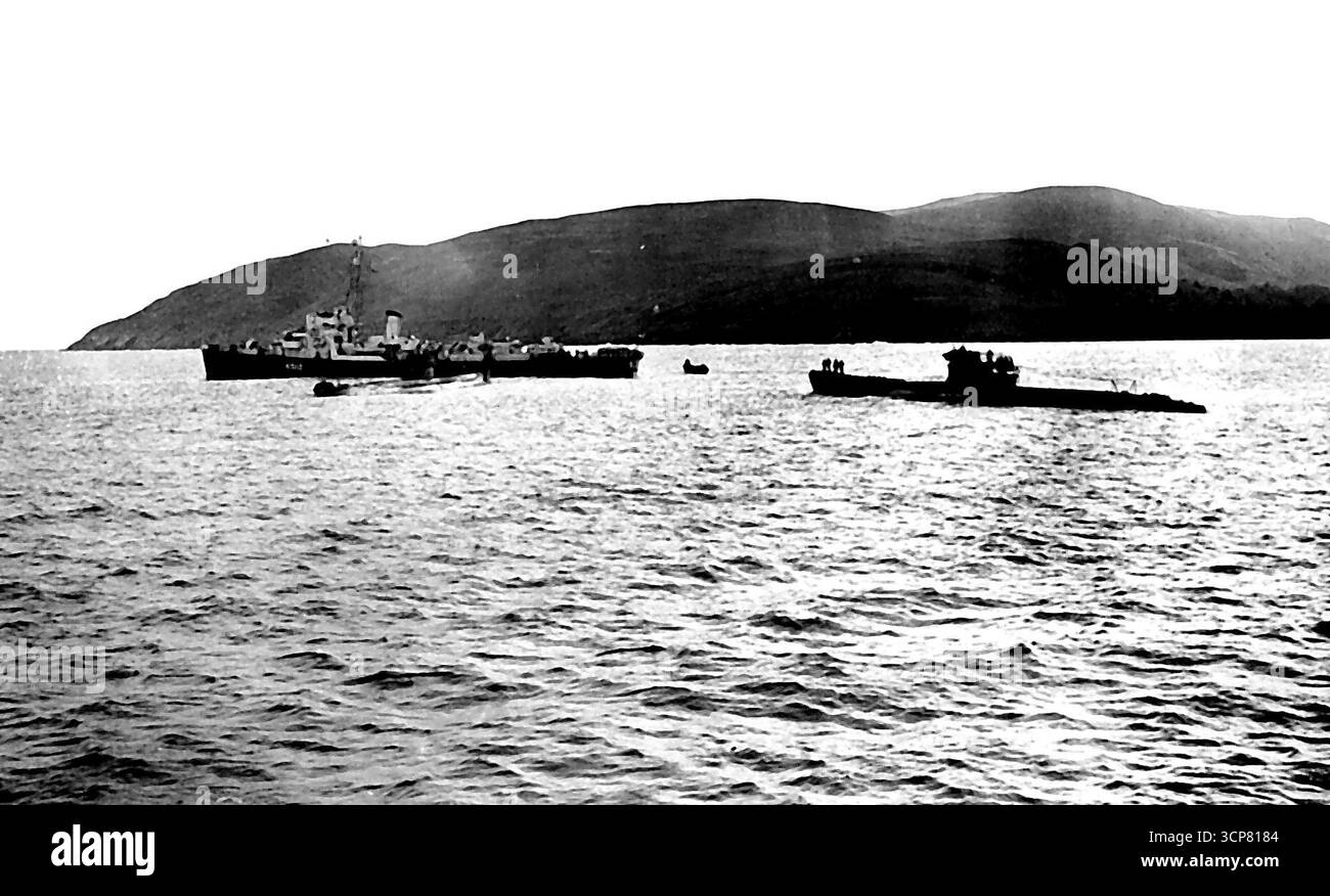 Un destroyer se met en position pour prendre la ligne de remorquage du U-boot. L'équipage allemand peut être vu sur le U-boat. « Deadlight » est le terme naval désignant l'opération des sous-marins allemands en naufrage dans l'Atlantique Nord, qui se déroule maintenant et se poursuivra pendant les deux ou trois prochains mois jusqu'à ce qu'ils aient tous (110 en tout) été éliminés de l'opération qui est dangereuse le deviendra encore plus car à cette époque de l'année le temps s'aggrave et les Gales deviennent fréquentes, sur cette opération le temps est devenu si mauvais que seulement 2 des 7 U-Boots ont atteint leur position de sabordage, les autres ont été coulés Banque D'Images