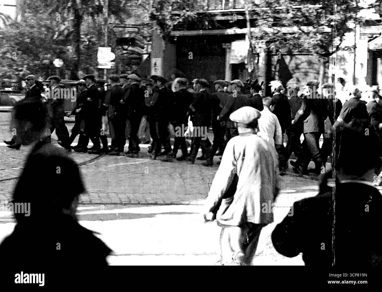 25 000 Allemands de plus pour la guerre d'Espagne -- troupes allemandes marchant à travers Séville en attendant l'uniforme de la Légion étrangère la semaine dernière. Les informations selon lesquelles l'Allemagne envoie 25 000 volontaires supplémentaires en Espagne et a déjà envoyé plusieurs navires de guerre sous des ordres mystérieux à Bilbao ont renforcé la tension en Europe causée par les craintes françaises d'un nouveau coup d'État d'Hitler sur sa frontière suisse. 28 décembre 1936. (Photo de Topical Press). Banque D'Images