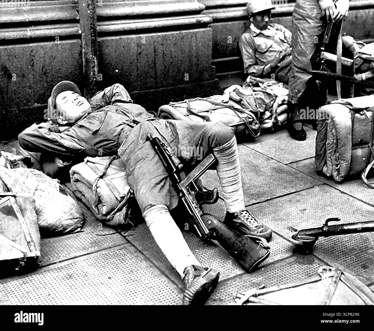 Le repos est là où vous le trouvez... son fusil tommy entre ses jambes, un soldat nationaliste chinois prend un peu de sommeil en attendant les ordres de déménager dans l'hôtel Cathay, propriété britannique, le 1er mai. Les troupes ont été déplacées dans les hôtels Cathay et Palace pour être à portée de main afin de préserver la loi et d'autres en cas de violence alors que les armées communistes chinoises se déplaçaient pour encercler la ville. 04 mai 1949. (Photo de AP Wirephoto). Banque D'Images