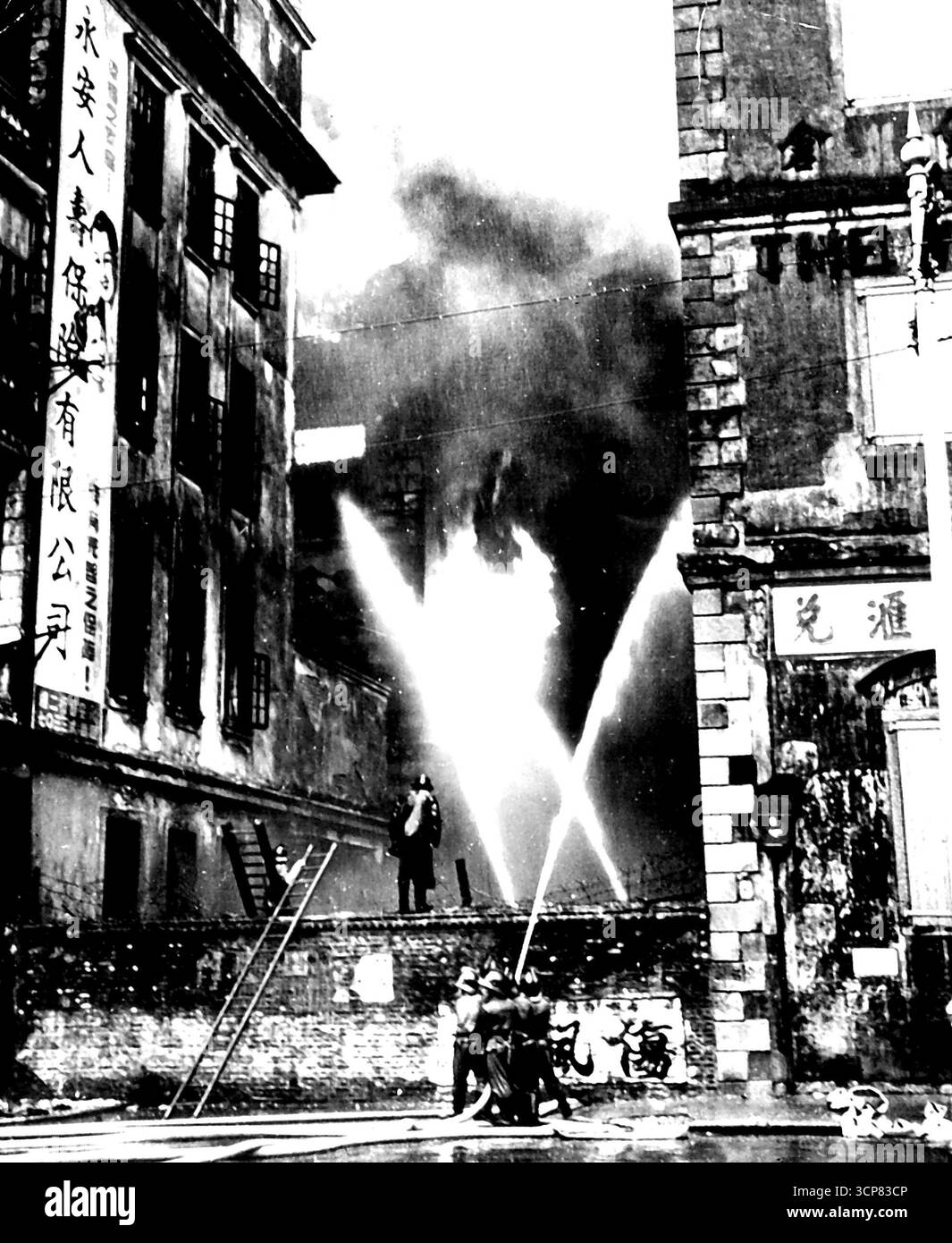 L'incendie de Hong Kong tue 137 -- les pompiers de Hong Kong jouent des flots d'eau sur un bâtiment d'entrepôt qui est toujours un enfer déchaîné 24 heures après qu'un incendie a commencé dans la structure. C'est le pire incendie de Hong Kong en 14 ans et 137 personnes ont été brûlées vives. Ceux qui sont morts vivaient dans les étages supérieurs de l'immeuble. Le feu a fait rage pendant quatre jours. 1er octobre 1948. (Photo de AP Wirephoto). Banque D'Images