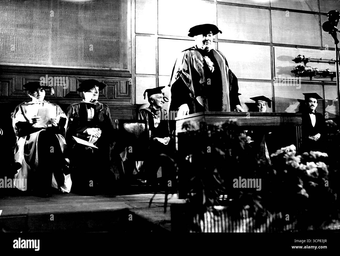 M.R. Churchill et d'autres reçoivent des diplômes honorifiques. -- M.R. Churchill parlant après la cérémonie. Dans le fond, de gauche à droite, sont : Sir Alexander Flaming, Mr. Walter de la Mare et Sir William Beveridge. Des diplômes honorifiques de l'Université de Londres ont été décernés à Mr. Churchill Mr. Walter de la Mare, le poète, Sir Alexander Fleming, découvreur de la pénicilline, Dr Fisher, archevêque de Cantarbury, Mr. Marshall secrétaire d'État des états-unis (absent de la cérémonie), et Sir Ernest Pooley, président du conseil des arts lors de la 112e célébration de la journée de fondation à l'Université hier soir (mar Banque D'Images