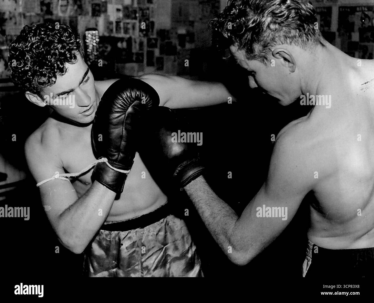 Colin Clarke, la main droite attachée, se concentre sur sa gauche lors d'un espar avec le poids bien-être Ney Lynch. Colin Clark, qui a son gant droit attaché à son corps pour pouvoir se concentrer sur ses coups de poing de la main gauche. 4 mai 1954. Banque D'Images