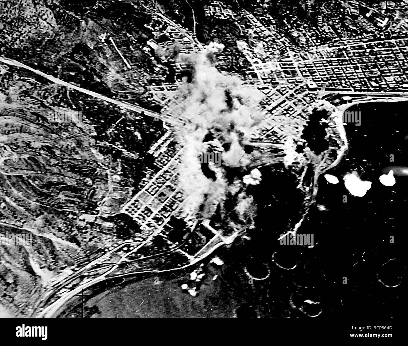 Les bombardiers américains font exploser des bombes du port italien de Reggio à partir d'avions des forces aériennes de l'armée américaine dans le port et la zone de quai et incendient le port de Reggio, en Italie. Ce raid faisait partie de l'offensive aérienne des Nations Unies contre l'axe. Reggio est un port clé à la pointe de la botte italienne face à la Sicile. 20 décembre 1943. (Photo du U.S. Office of War information Picture). Banque D'Images