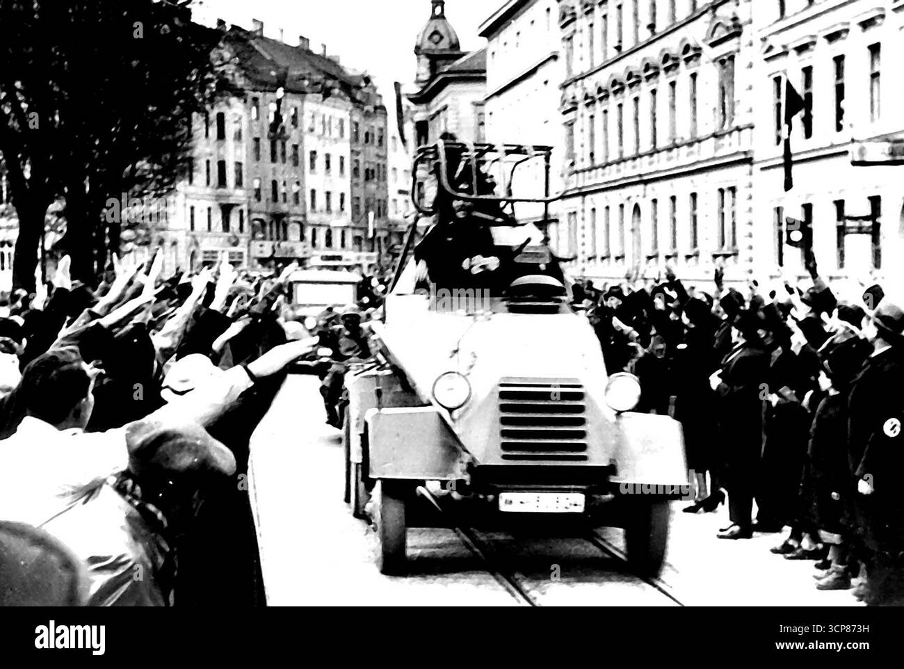 Troupes autrichiennes en Autriche -- les citoyens de Linz ici accueillent les troupes allemandes du NG qui font une invasion pacifique et triomphante aujourd'hui. L'homme conduisant la voiture blindée semble être parfaitement heureux. Les troupes allemandes sont entrées ici aujourd'hui, d'autres conduisant dans les rues des voitures blindées modernes. Ils sont arrivés peu de temps avant Herr Hitler lui-même. Ils ont été accueillis par des nazis qui célébraient le coup d'État allemand qui a conduit à la chute du chancelier Kurt von Schuschnigg et des membres de son ministère. 11 avril 1938. (Photo d'Associated Press photo). Banque D'Images