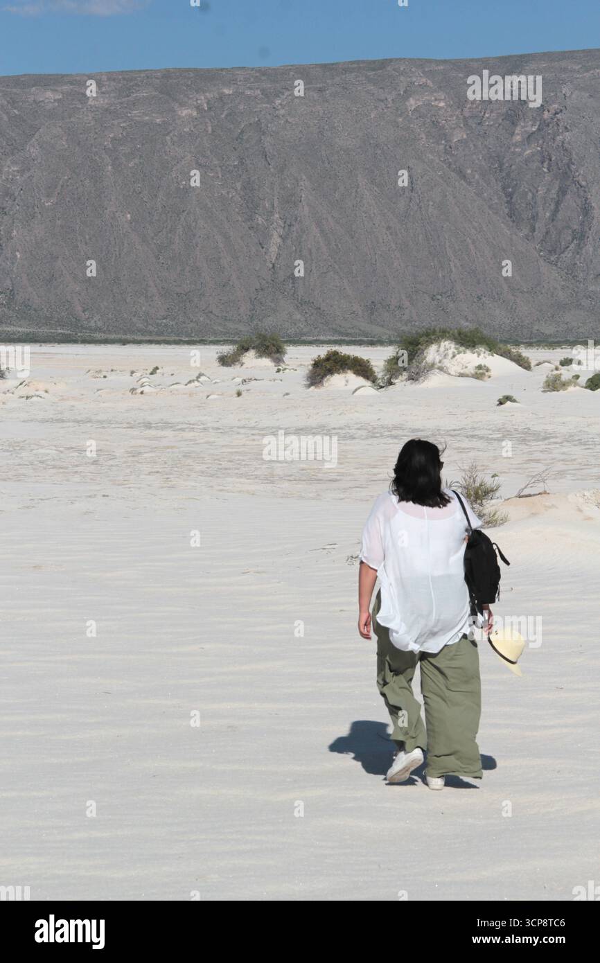 Brunette Latina femme adulte marche à travers les dunes de gypse au milieu du désert blanc profitant de la liberté et de la plénitude de sentir la nature Banque D'Images