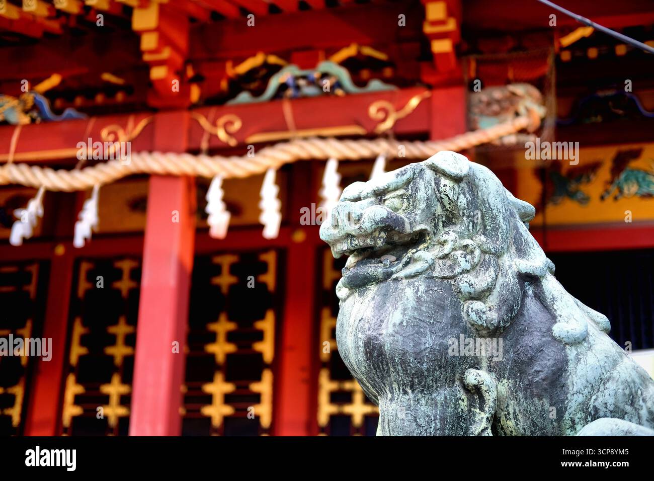 Chien lion komainu en pierre gardant l'entrée du temple Senso-ji et du sanctuaire shinto à Asakusa, Tokyo, Japon ; destiné à éloigner les mauvais esprits. Banque D'Images