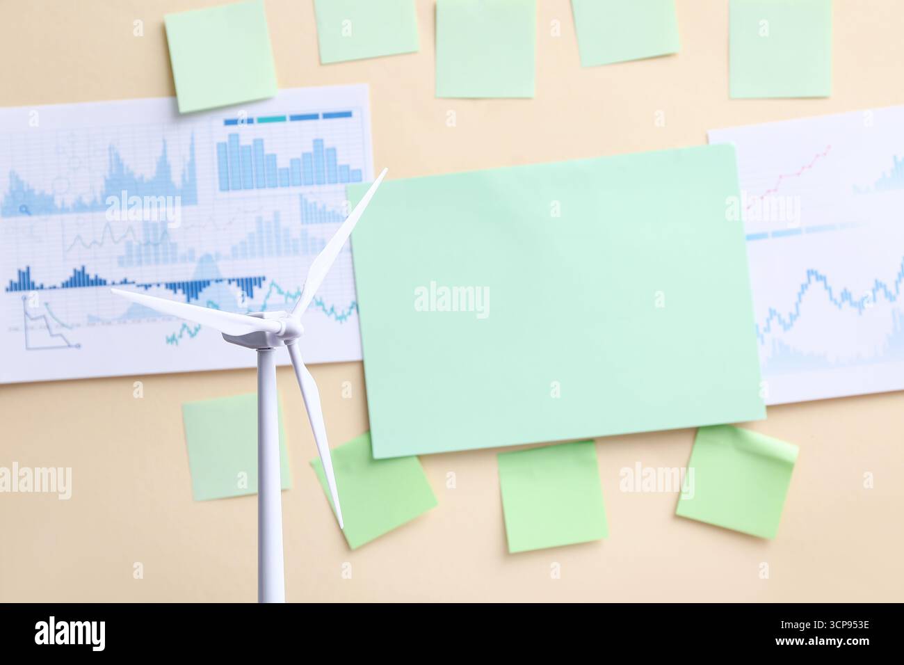 Éolienne papiers modernes et vierges avec des diagrammes sur le mur beige Banque D'Images