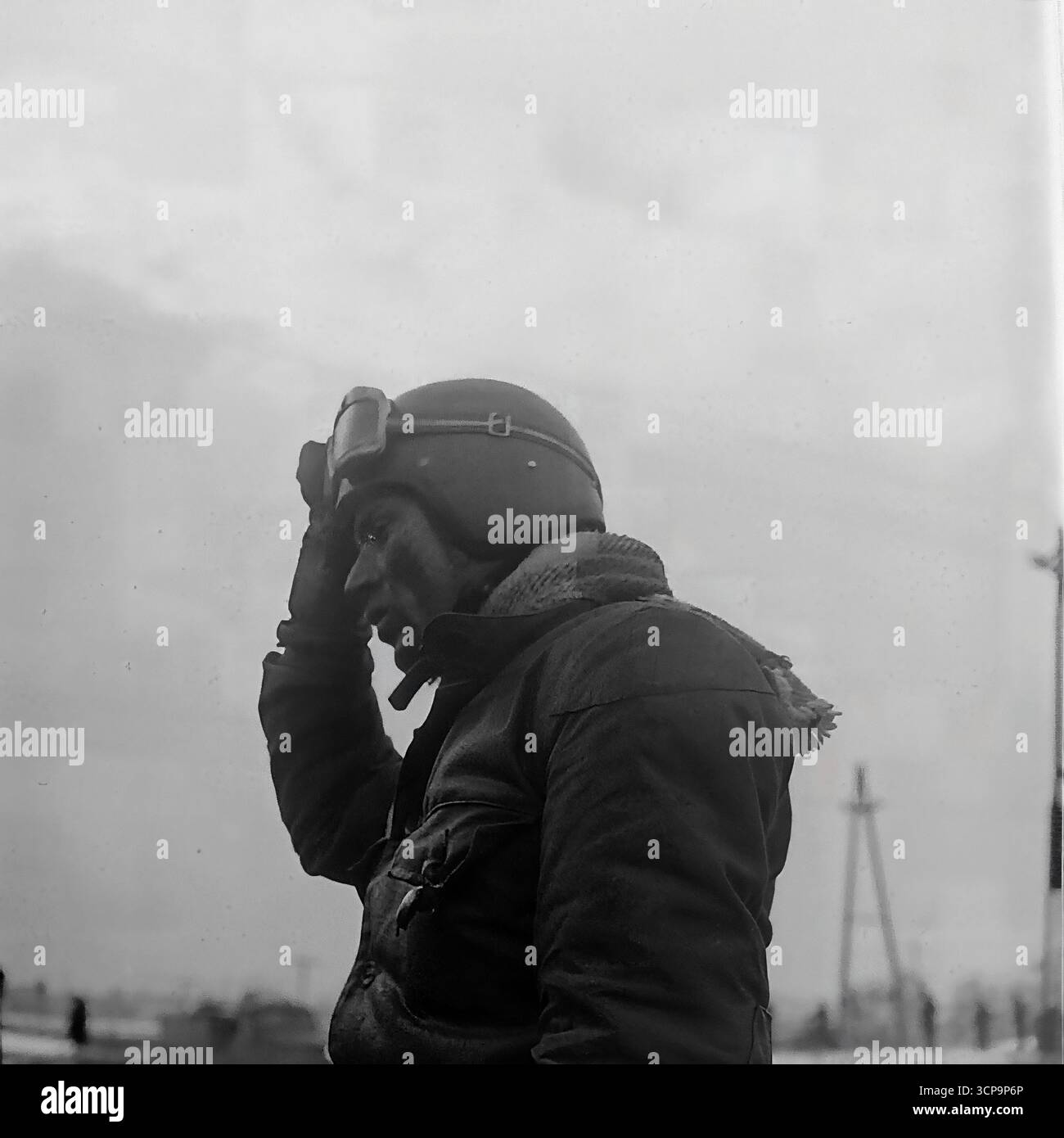 Un puissant portrait en gros plan de 1975 montre un coureur de motocross soviétique épuisé, son visage éclaboussé de boue, peu de temps après une course d'hiver épuisante à Sloviansk, en RSS d'Ukraine. Le cavalier, portant un casque vintage avec des lunettes repoussées, révèle le bilan physique et la détermination pure nécessaires pour ce sport exigeant. Cette photographie en noir et blanc est une représentation intemporelle et graveleuse de l'endurance et de l'esprit d'un athlète Banque D'Images