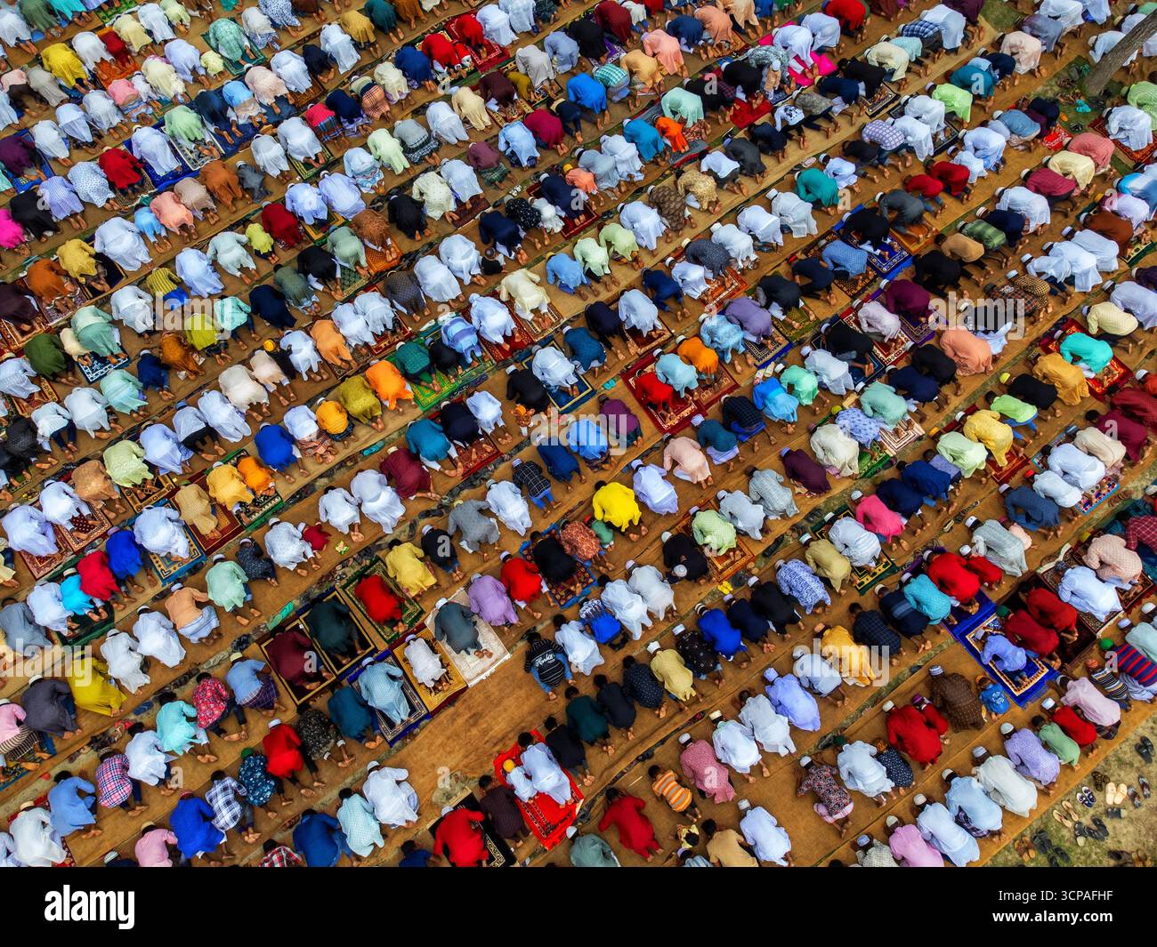 Joypurhat, Bangladesh - 22 avril 2023 : vue aérienne d'une multitude de personnes rassemblées à Akkelpur, la tête inclinée dans la prière, créant une mosaïque de couleurs vives et d'unité pieuse. Banque D'Images