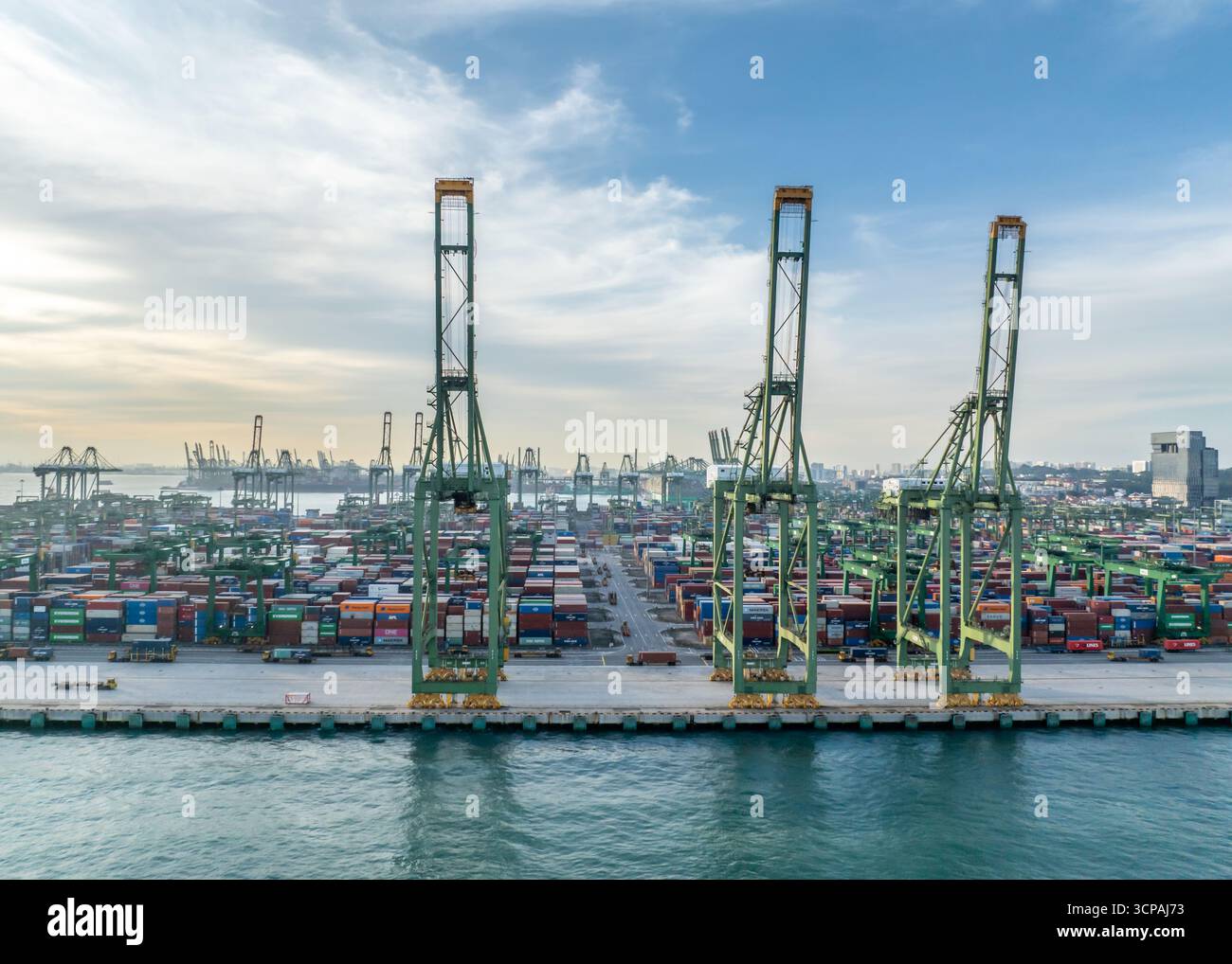 Singapour, Singapour - 06 décembre 2024 : vue aérienne de l'immense terminal de Pasir Panjang, une symphonie de conteneurs empilés sous d'imposantes grues contre un ciel serein. Banque D'Images