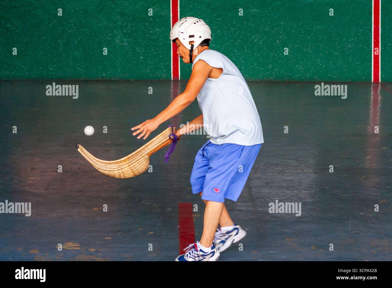 Un pelotari philippin jouant au jai alai, un sport basque autrefois très populaire aux Philippines, dans un fronton local à Manille Banque D'Images