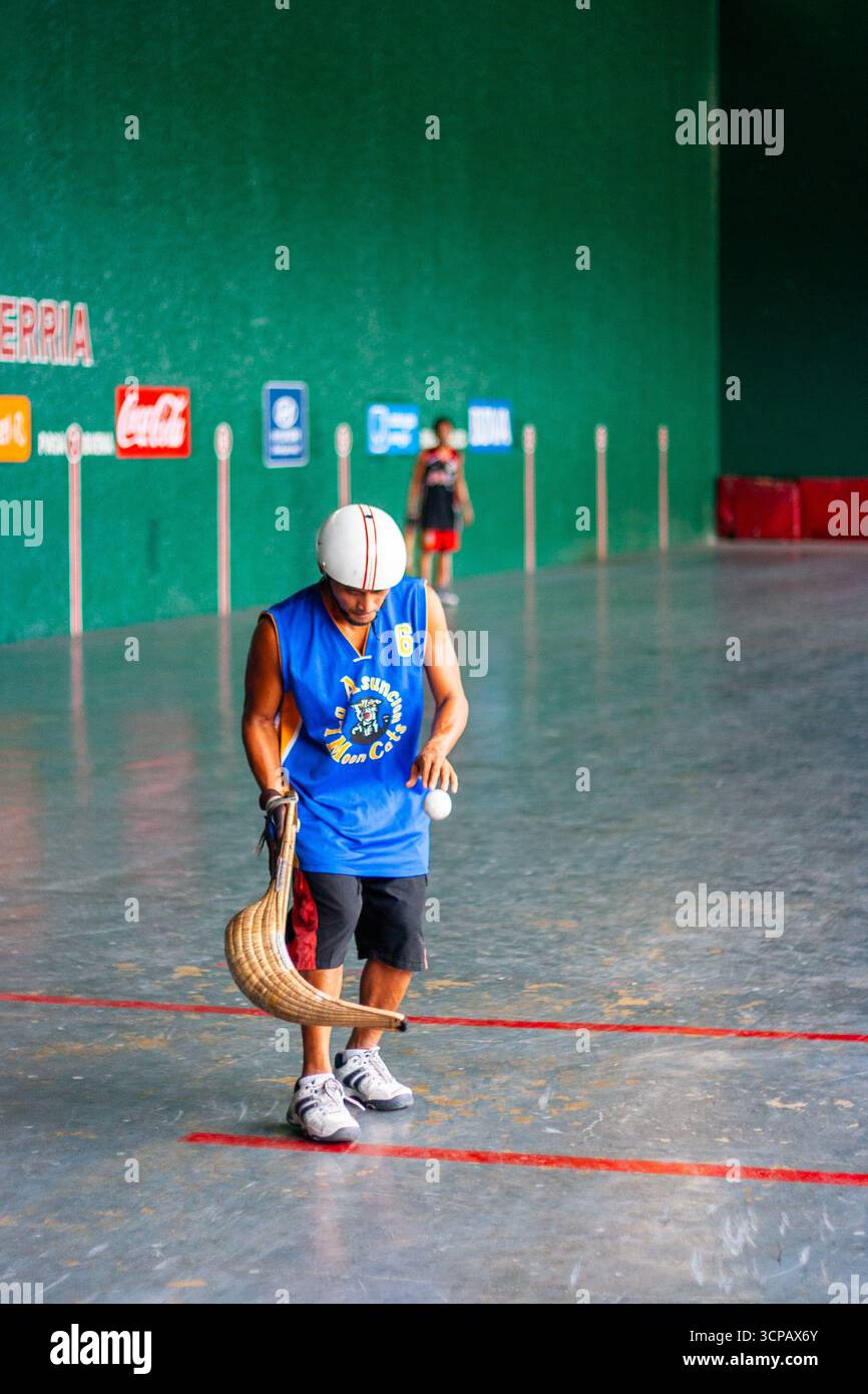 Un pelotari philippin avec sa cesta jouant au jai alai, un sport basque autrefois très populaire aux Philippines, dans un fronton local à Manille Banque D'Images