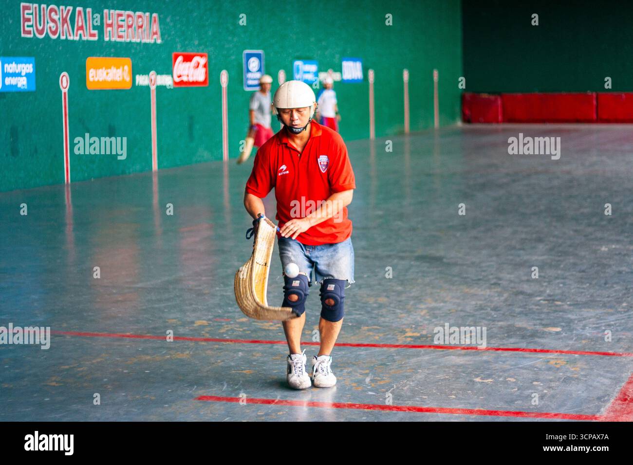 Un pelotari philippin avec sa cesta jouant au jai alai, un sport basque autrefois très populaire aux Philippines, dans un fronton local à Manille Banque D'Images