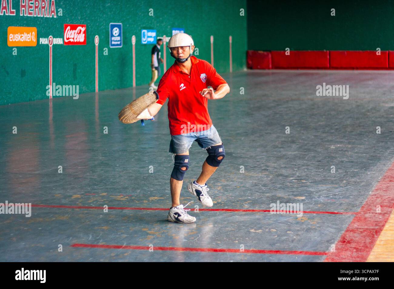 Un pelotari philippin avec sa cesta jouant au jai alai, un sport basque autrefois très populaire aux Philippines, dans un fronton local à Manille Banque D'Images