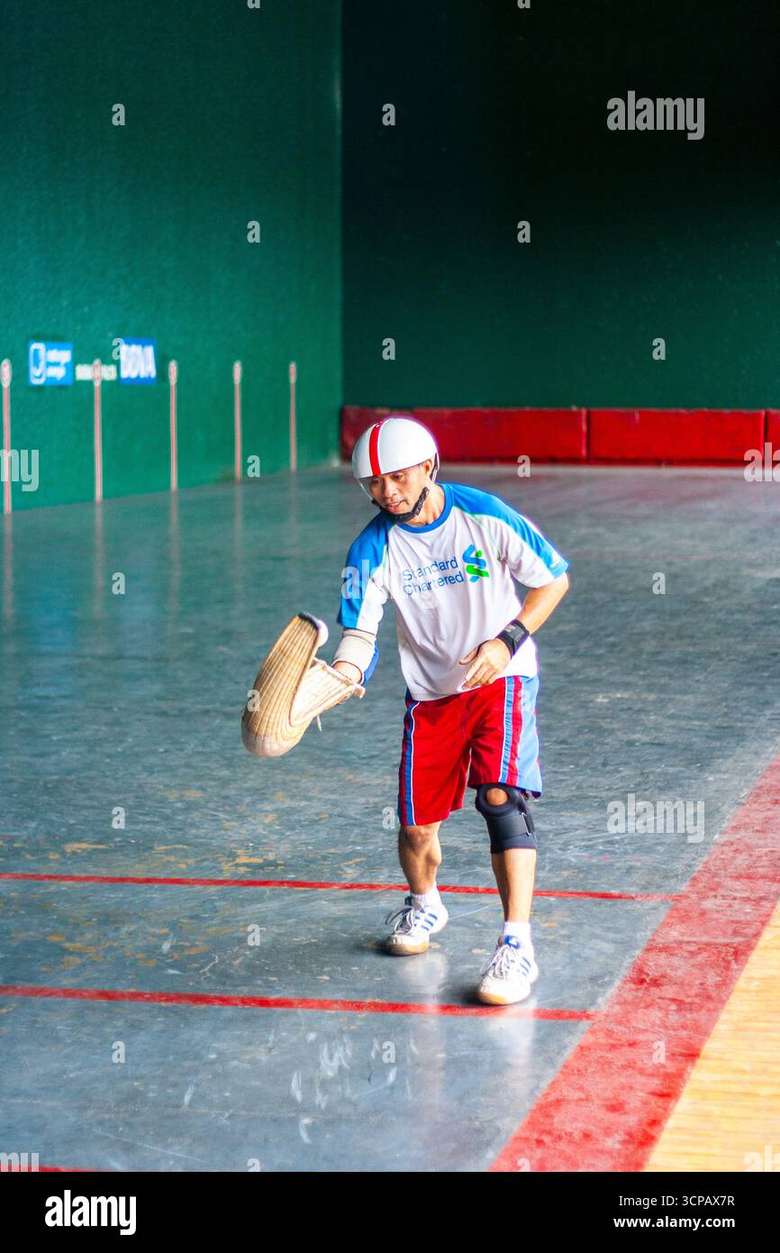 Un pelotari philippin jouant au jai alai, un sport basque autrefois très populaire aux Philippines, dans un fronton local à Manille Banque D'Images