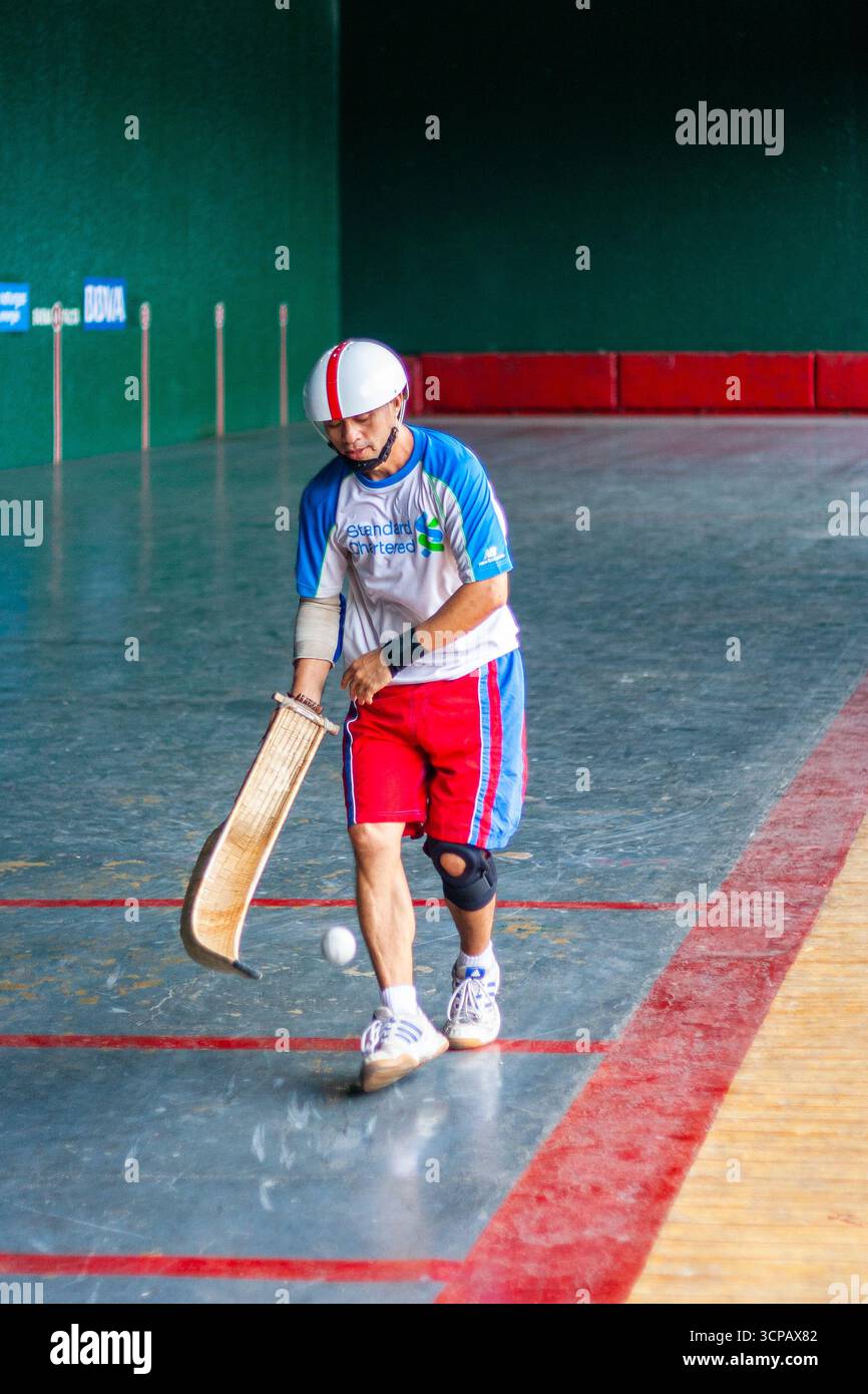 Un pelotari philippin jouant au jai alai, un sport basque autrefois très populaire aux Philippines, dans un fronton local à Manille Banque D'Images