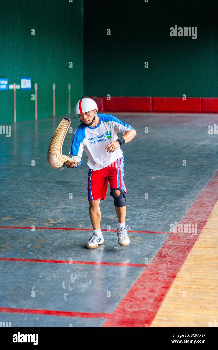 Un pelotari philippin jouant au jai alai, un sport basque autrefois très populaire aux Philippines, dans un fronton local à Manille Banque D'Images