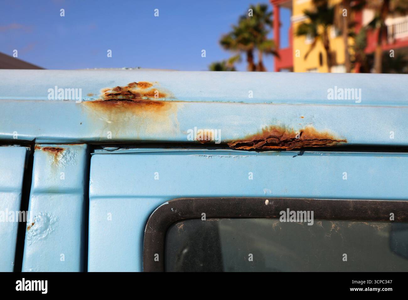 Corps rouillé dans une vieille voiture bleue. Dommages causés par les intempéries du véhicule. Banque D'Images