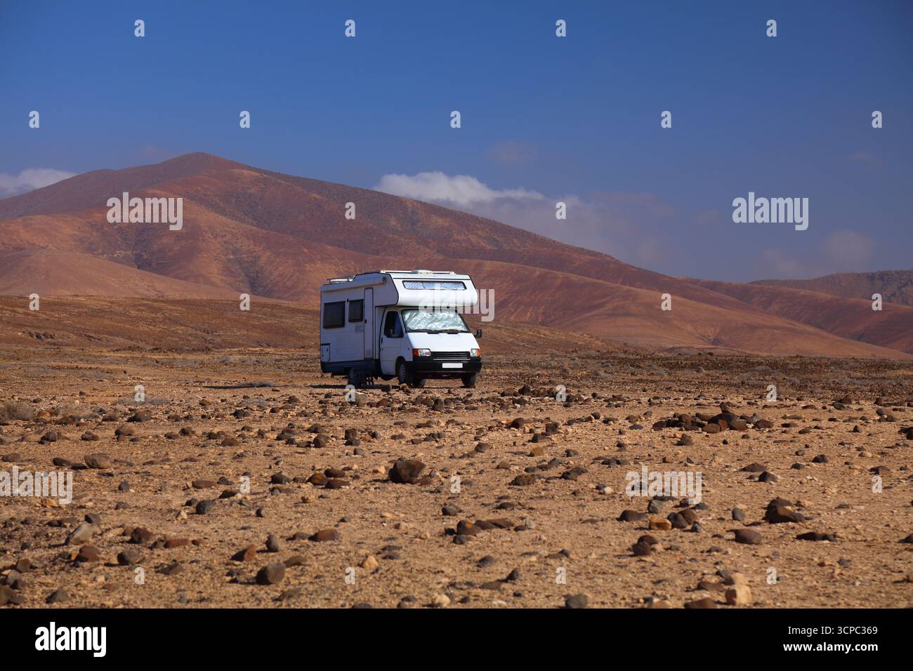 Vieux camping-car blanc garé dans le paysage désertique d'Ajuy dans l'île de Fuerteventura des îles Canaries, Espagne. Banque D'Images
