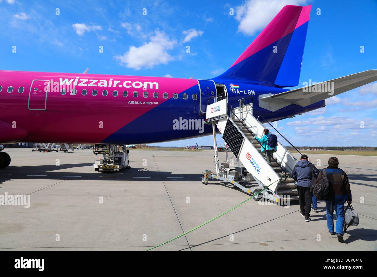 KATOWICE, POLOGNE - 5 AVRIL 2025 : les gens montent à bord d'un avion Airbus A321 NEO de la compagnie aérienne Wizzair low cost par des escaliers à l'aéroport international de Katowice en Pologne Banque D'Images