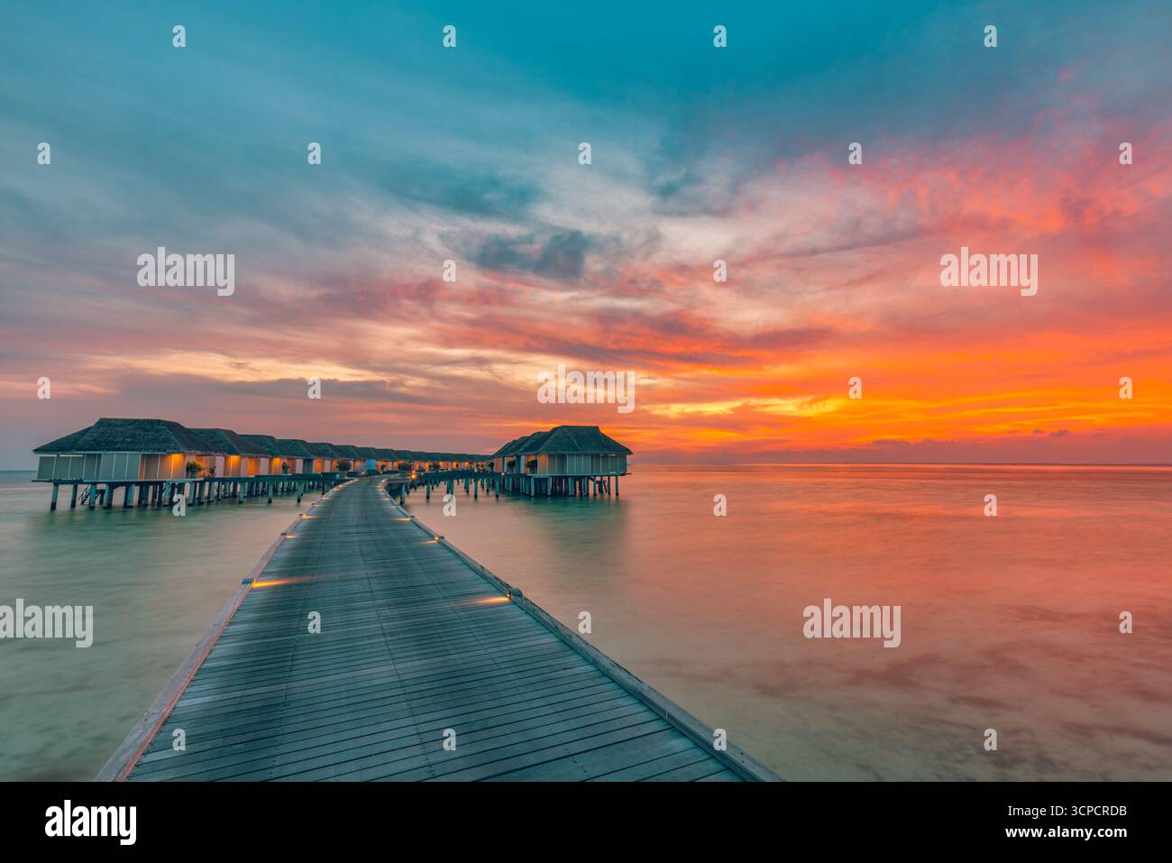 Fantastiques villas d'eau de coucher de soleil avec jetée en bois dans la station balnéaire des Maldives plage d'été populaire île tropicale voyage paysage coloré de ciel de mer scène de vacances Banque D'Images