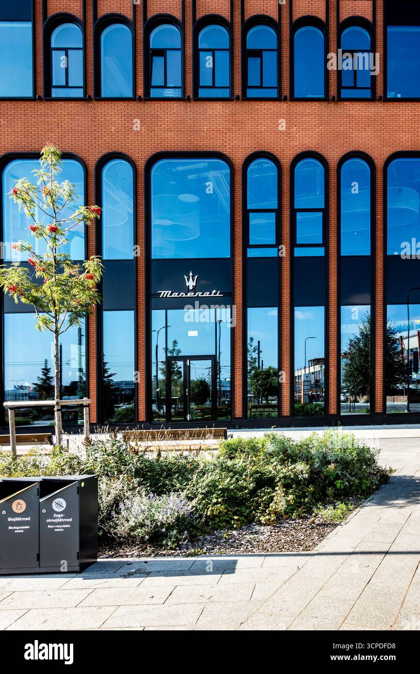 Maserati showroom à Tallinn, Estonie, situé dans un bâtiment moderne en briques rouges et en verre avec de hautes fenêtres cintrées et un environnement urbain paysager. Banque D'Images